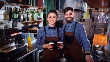 two baristas holding coffee