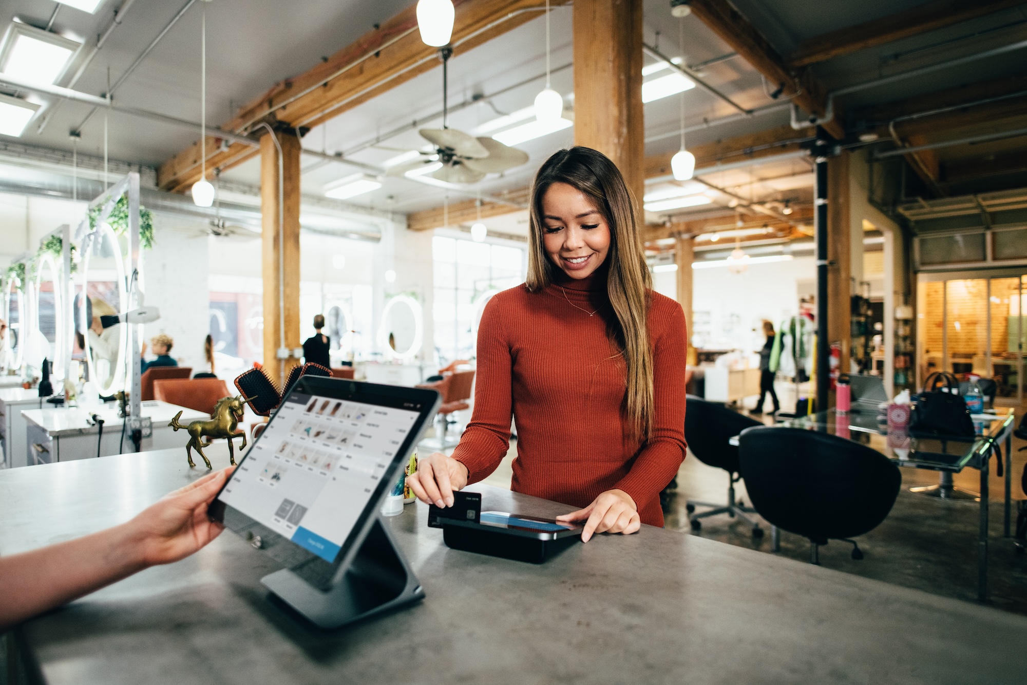 A brightly lit retail store with employees helping customers.
